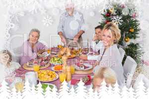 Composite image of happy family at christmas dinner