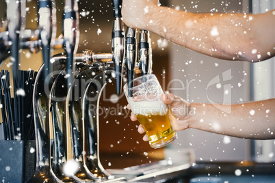 Composite image of barmans arms pulling a pint of beer