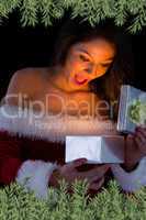 Pretty brunette in santa outfit opening gift