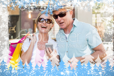 Happy mature couple looking at smartphone together in the city