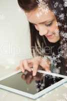 Relaxing girl looking and using a tablet pc on a sofa