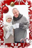 Composite image of happy mature couple in winter clothes holding mugs