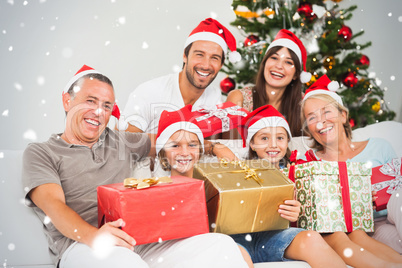 Composite image of happy family at christmas holding gifts