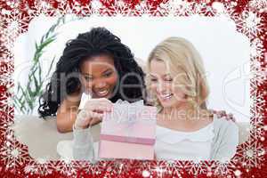 Composite image of two women look inside a pink box