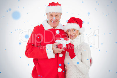 Festive couple smiling and holding gift