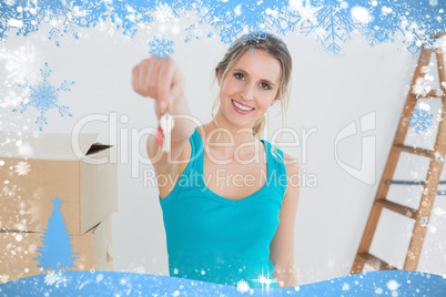 Woman holding out with key besides boxes in new house