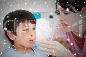 Composite image of caring nurse taking her patients temperature