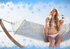 Smiling blonde wearing sunhat sitting on hammock with cocktail