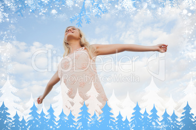 Young woman in summer dress stretching arms against sky