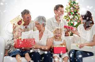 Composite image of family opening christmas gifts at home