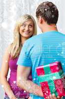 Composite image of cute boyfriend giving a present