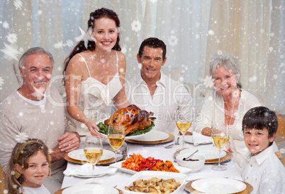 Composite image of family eating turkey in a dinner