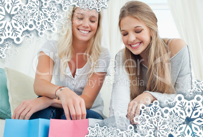 Smiling girls looking into the bags below them