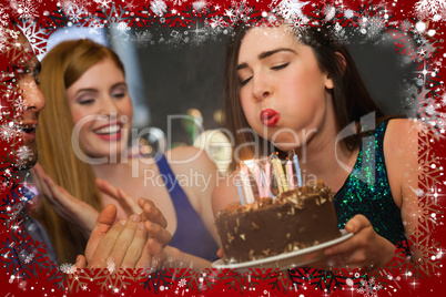 Attractive woman blowing the candles on her birthday cake