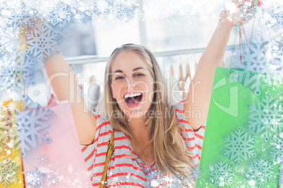 Composite image of blonde woman raising shopping bags