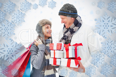 Mature couple in winter clothes holding gifts