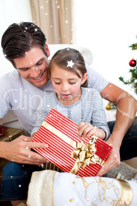 Composite image of surprised little girl holding a christmas pre