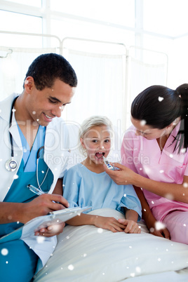 Composite image of young nurse taking her child patients tempera