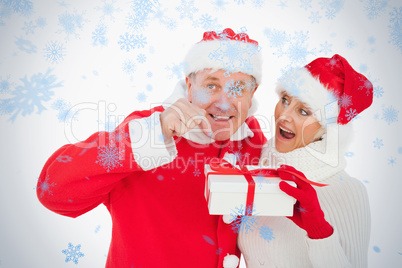 Festive couple smiling and holding gift