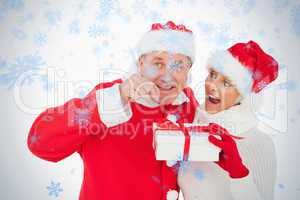 Festive couple smiling and holding gift