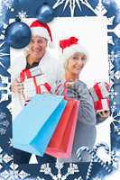 Composite image of festive mature couple in winter clothes holding gifts and bags