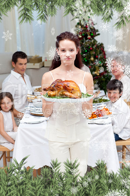 Composite image of mother showing turkey for christmas dinner