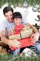 Happy father and son holding christmas presents