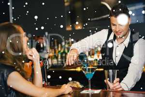 Handsome bartender serving cocktail to attractive woman