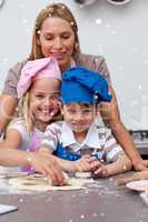 Mother helping her children baking