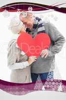 Composite image of happy mature couple in winter clothes holding red heart