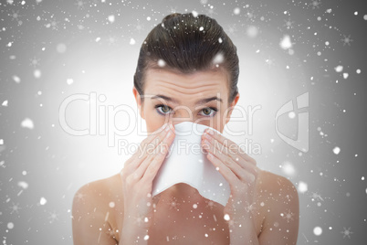 Sick natural brown haired model sneezing in a tissue