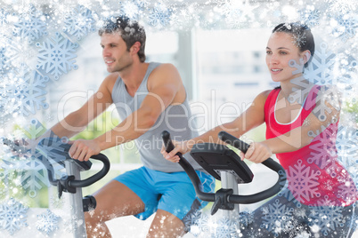 Fit young couple working out at spinning class