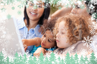 Composite image of family having a good time at the laptop toget