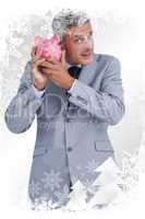 Composite image of curious businessman holding piggy bank