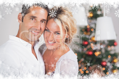 Composite image of couple embracing at christmas