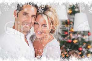 Composite image of couple embracing at christmas