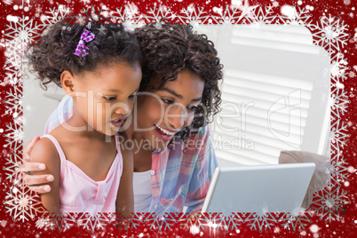 Cute daughter using laptop at desk with mother