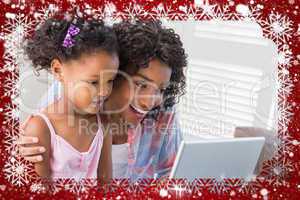 Cute daughter using laptop at desk with mother