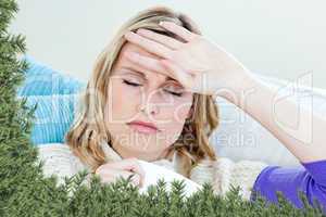 Sick woman with headache lying on the sofa in the livingroom