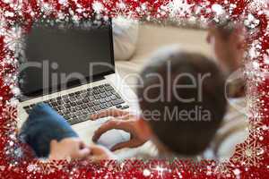 Father and son using laptop in house