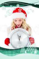 Composite image of festive blonde holding large clock