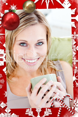 Positive blond woman holding a cup smiling at the camera