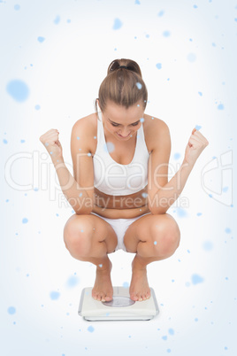 Composite image of successful young woman crouching on a scales