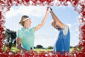 Golfing couple high fiving on the golf course