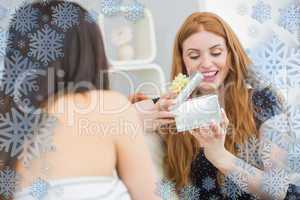 Composite image of young woman surprising friend with a gift