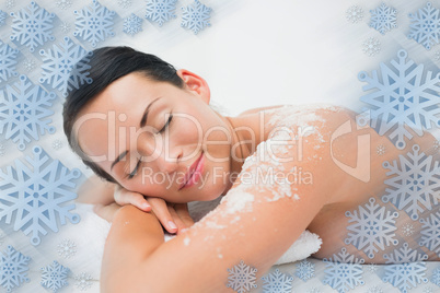 Peaceful brunette lying with salt scrub on shoulders