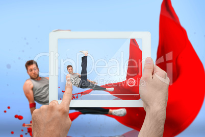 Composite image of hand holding tablet pc