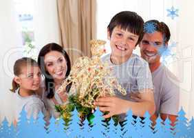 Happy little boy decorating a christmas tree with his family