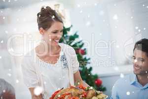 Attractive woman bringing a roast chicken at table