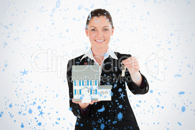 Good looking woman in suit holding keys and a miniature house